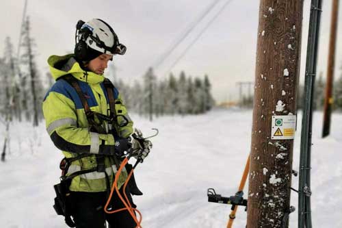 Elektriker som jobbar vid en elstolpe