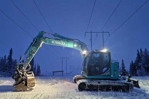 Grävmaskin som står i vintermiljö