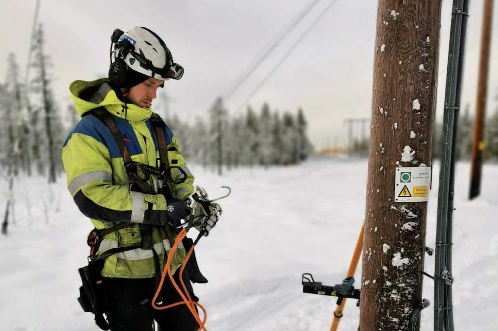 Man som gör sig redo att klättra upp för elstolpe