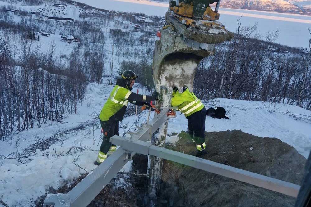 Två män som står vid en grävskopa